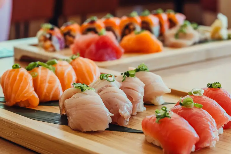 Nigiris saumon, hamachi et thon sur planche de bois