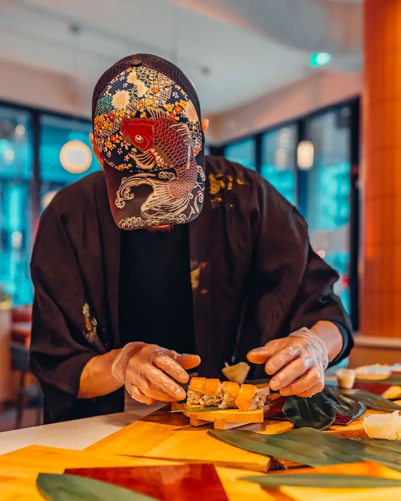 Le chef dresse un uramaki au comptoir