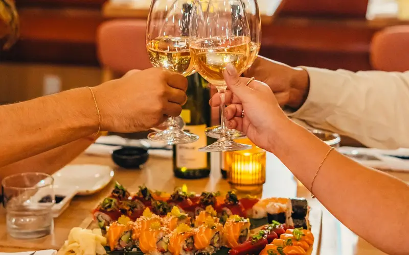 Une tablée trinque au-dessus des plateaux de sushis